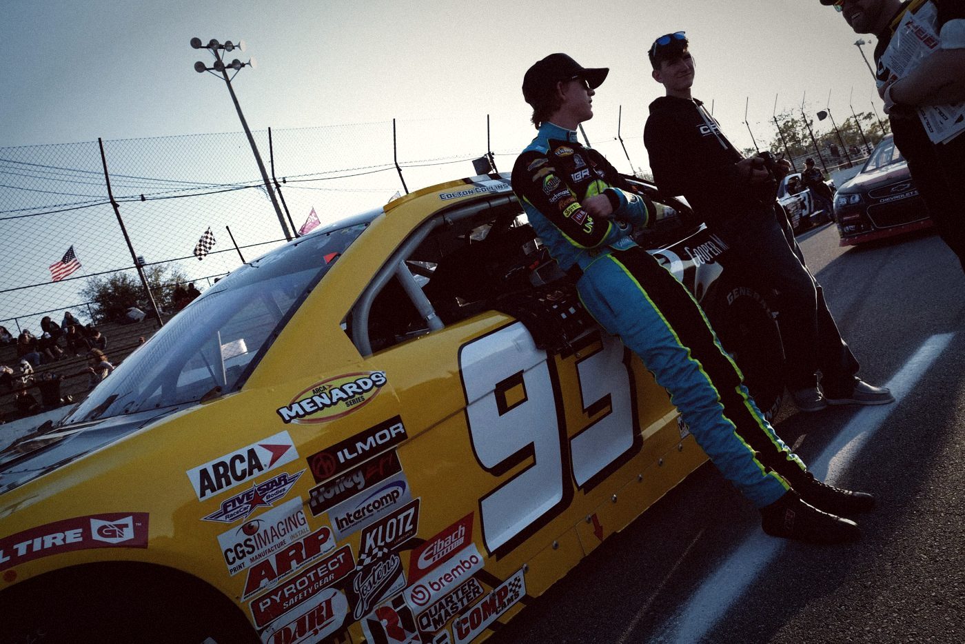 An ARCA driver leaning on his car on pit road before the race