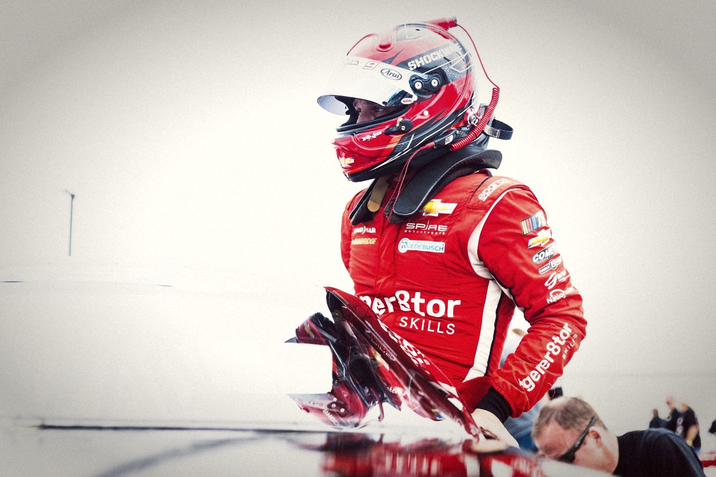 A driver climbing into his car before a race