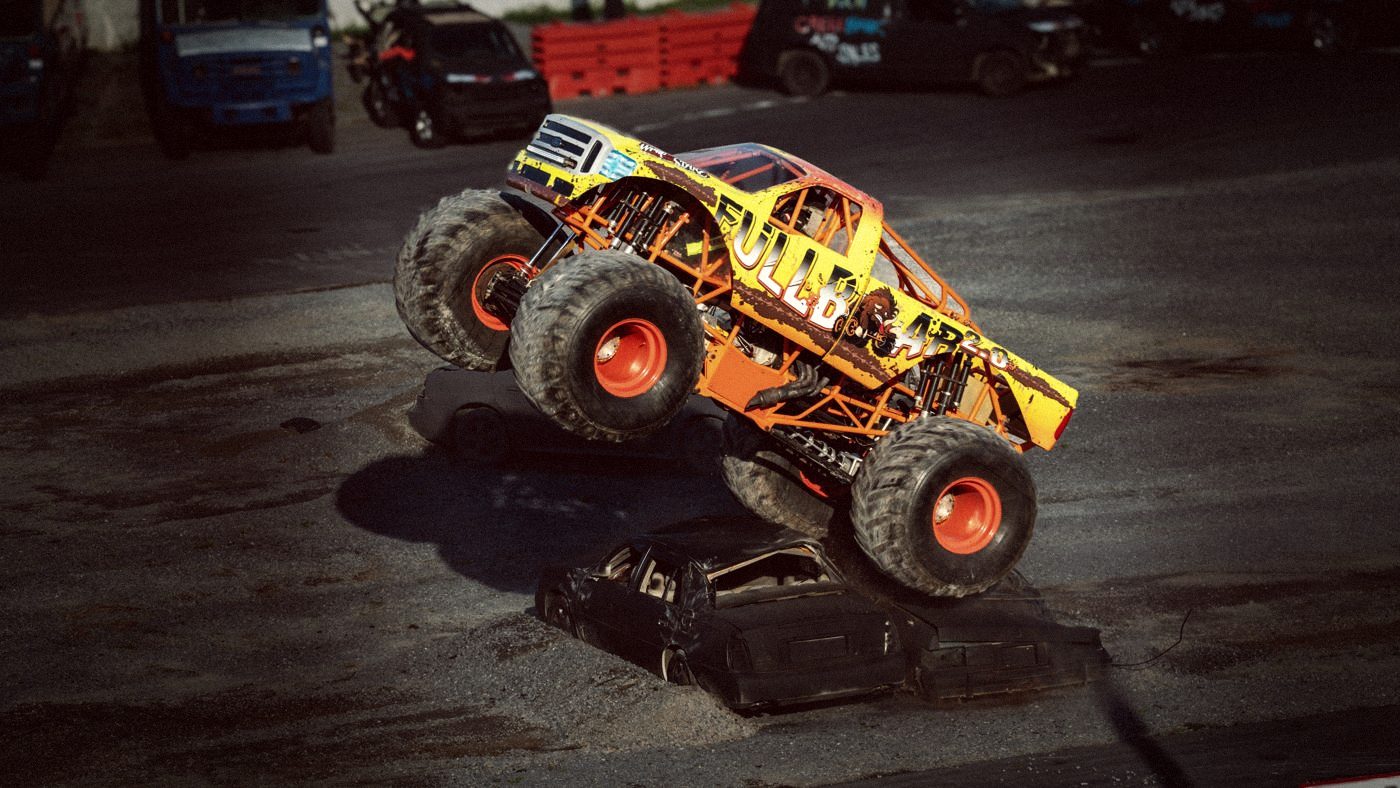 A monster truck mid-jump under the lights